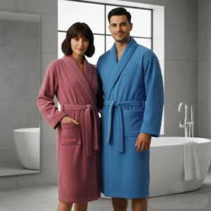 Pareja usando albornoz Trovador unisex 100% algodón en rosa y azul, suaves y absorbentes, perfectos para regalar en España