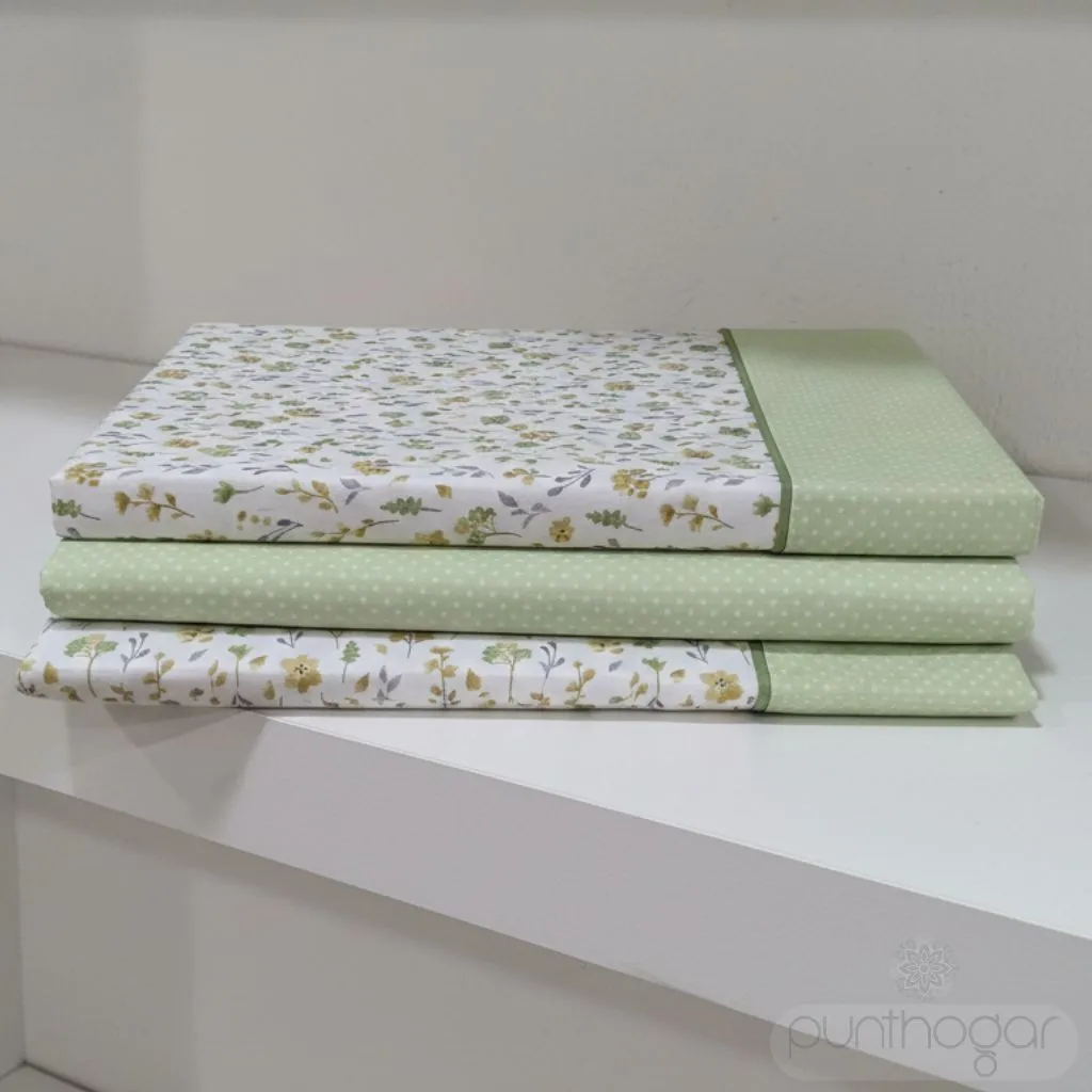 Sábanas MILOS color verde de ABECÉ dobladas en estantería, diseño floral con detalles en verde y lunares blancos.